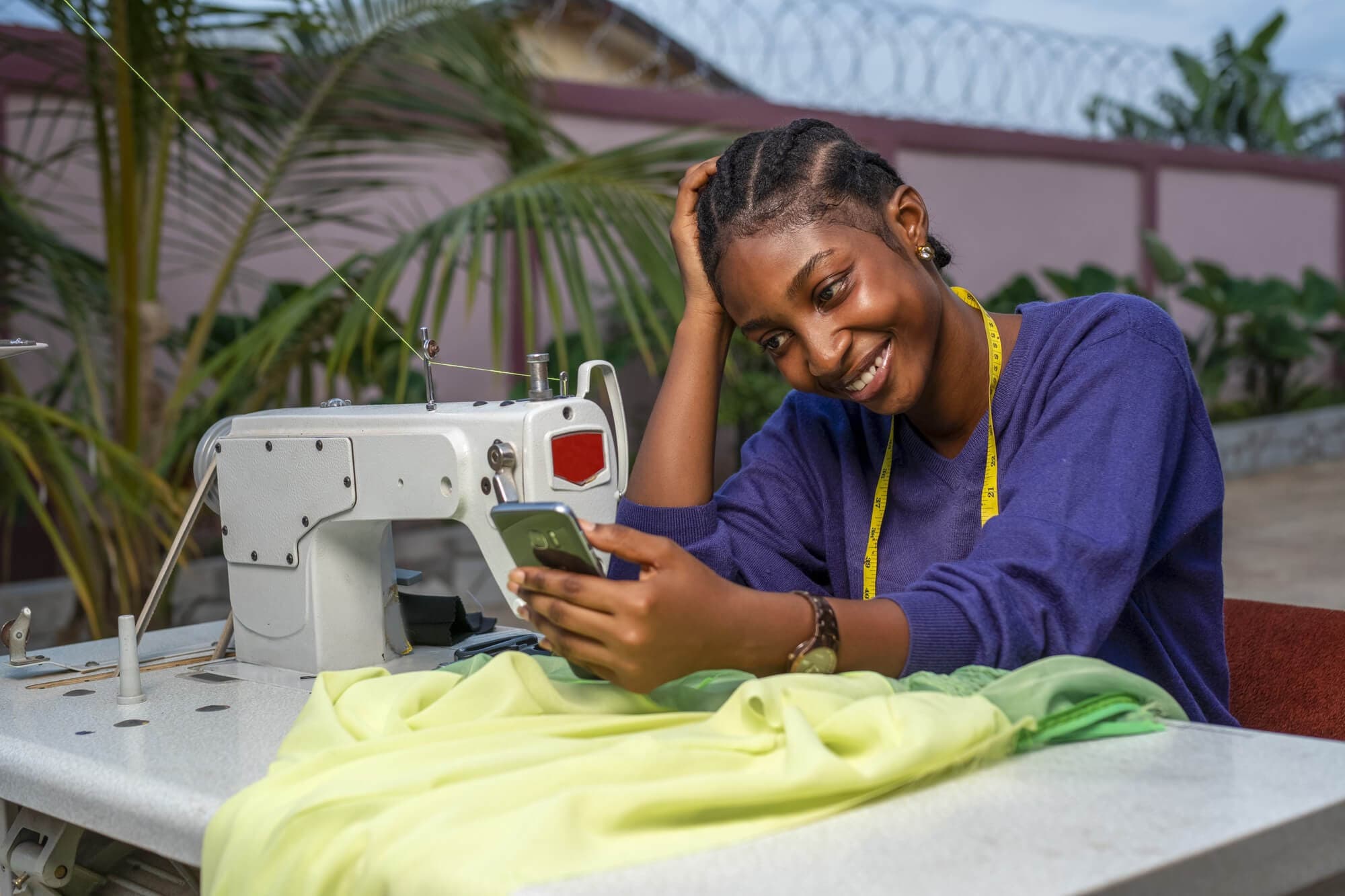 Tailor finishing a garment at her sewing machine